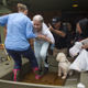 An elderly woman leaves her home and is helped into a boat after flooding caused by heavy rain during Hurricane Harvey August 29, 2017 in the Bear Creek neighborhood in west Houston, Texas (Photo by Erich Schlegel/Getty Images)